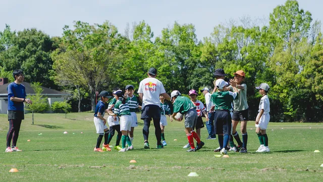 小学生クラスがミニラグビーの練習でパスをつないでいる様子