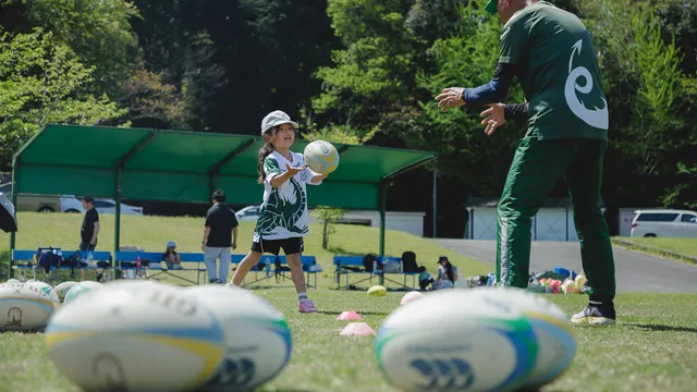幼児クラスの子どもたちがタグラグビーで元気に走っている様子