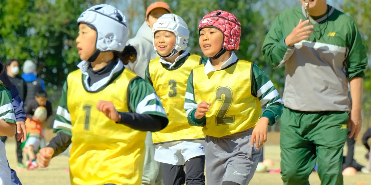 Children practicing rugby together on the field