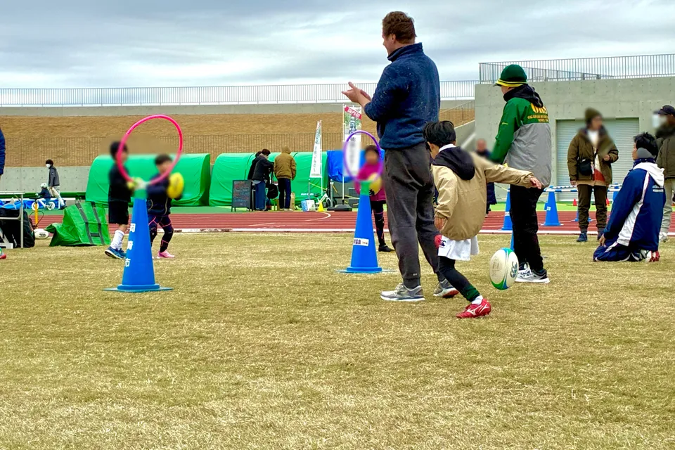 子どもたちが笑顔でラグビー体験に参加している様子